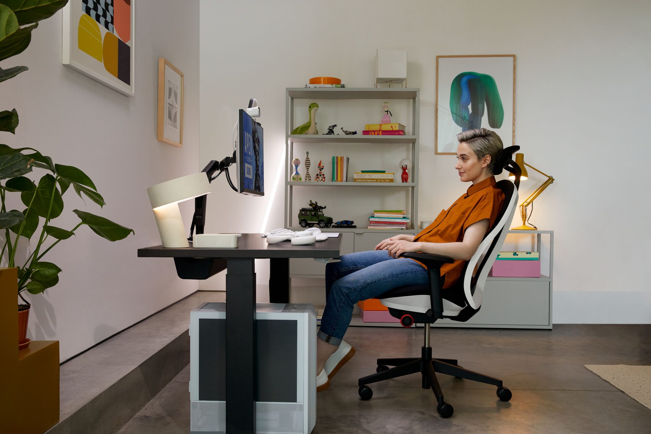 Pessoa sentada em cadeira ergonômica em home office.