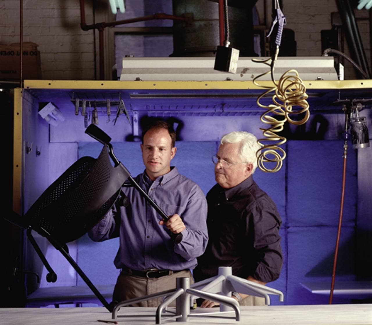 Bill Stumpf e Jeff Weber examinam uma cadeira Herman Miller