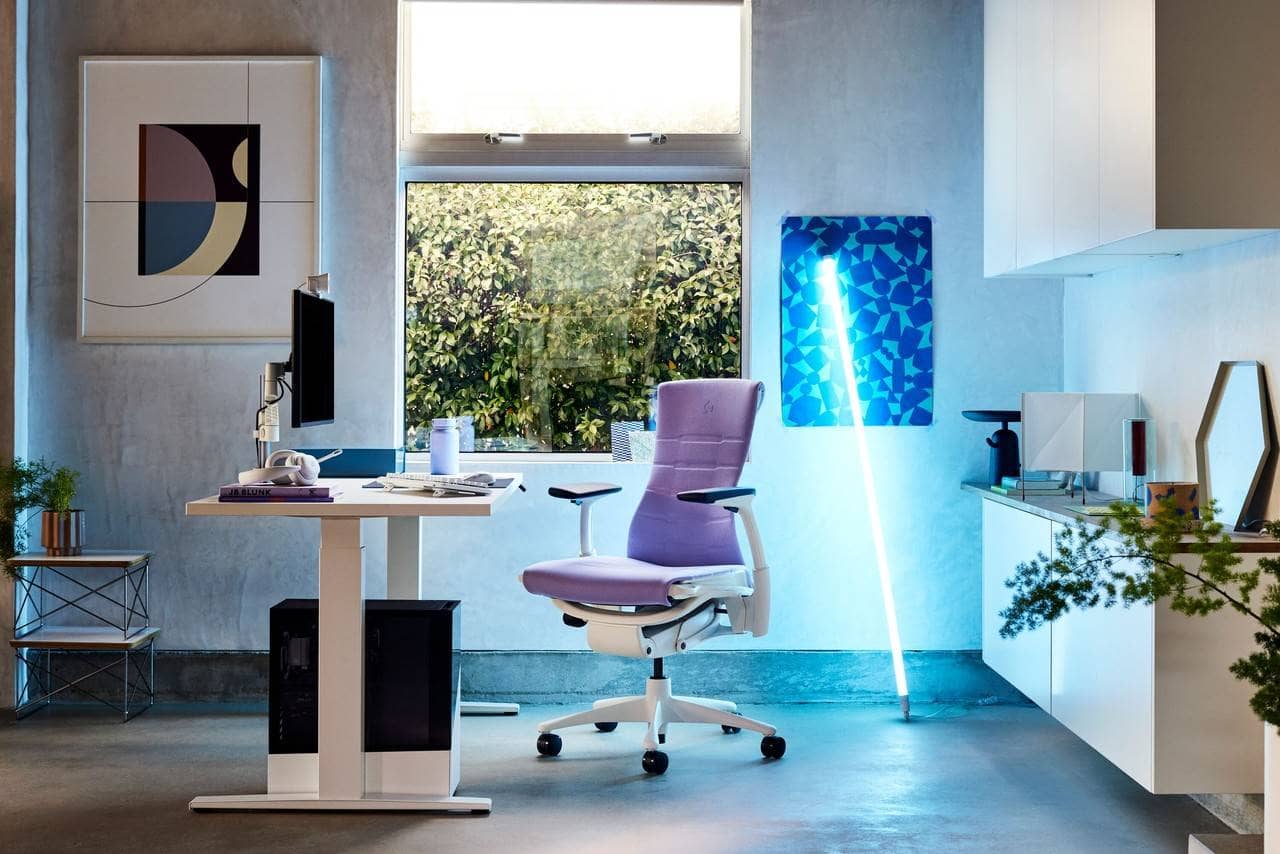 espaço de trabalho com mesa ergonômica e cadeira embody lilás com um bastão de luz azul no fundo