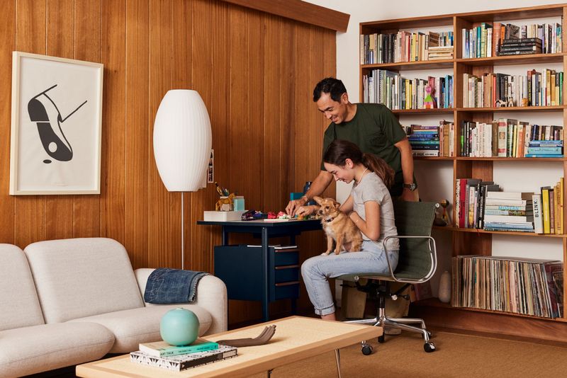 casal em um escritório home office sentados em uma cadeira herman miller