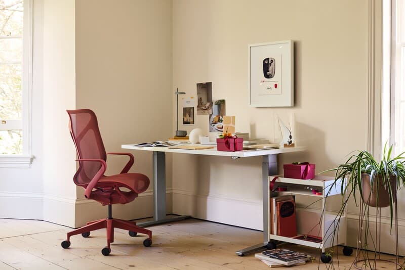 Escritório moderno com cadeira rosa e mesa branca.