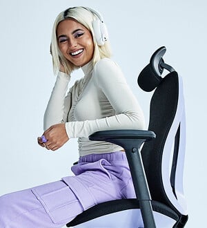 Mulher sorrindo com fones em cadeira de escritório