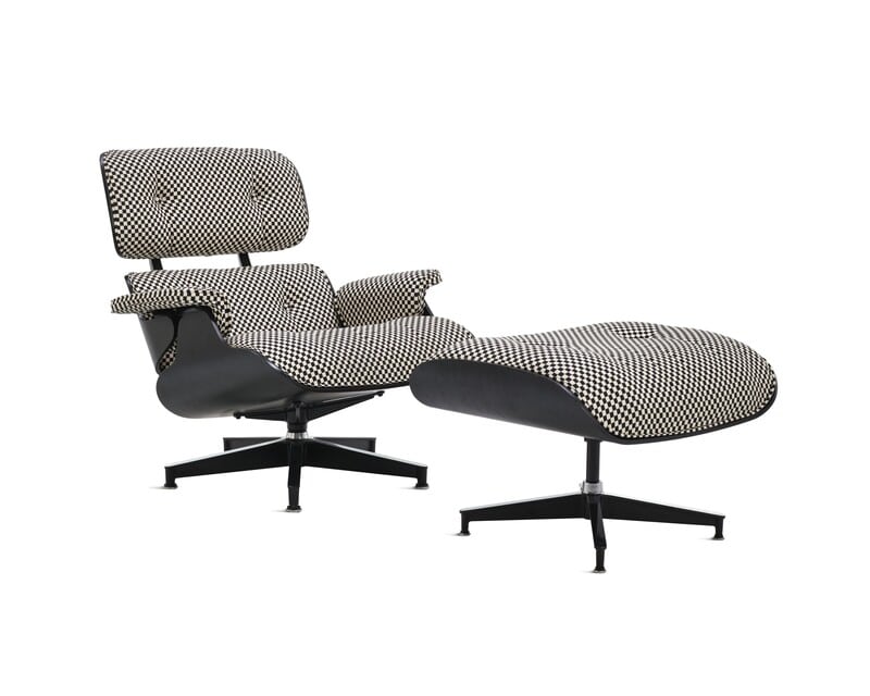 Poltrona moderna em preto e branco com descanso para os pés.