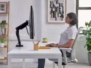 Postura correta para sentar: benefÃcios, dicas práticas e mais Pessoa trabalhando em um escritório moderno e organizado