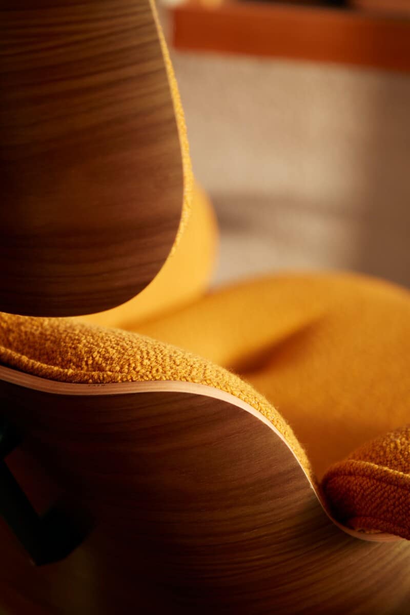 Cadeira moderna com estofado amarelo e design curvo