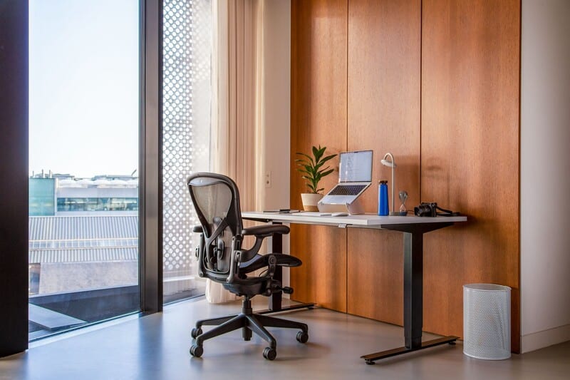 Escritório moderno com mesa, cadeira e vista externa